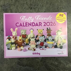 May include: A calendar titled "Fluffy Friends CALENDAR 2026" featuring 12 adorable animal patterns to make. The cover is pink with illustrations of knitted animal figures, including a rabbit, bear, and penguin. The calendar is from Simply Knitting and Stylecraft.