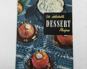 May include: A vintage cookbook titled "250 Delectable Desserts" with a black and gold title. The cover features images of desserts, including baked apples with whipped cream. The background has a blue and white striped pattern.
