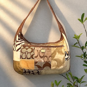 Puede incluir: Un bolso de hombro de patchwork con una mezcla de telas marrones y beige, que incluye patrones de logotipo característicos, rayas de cebra y detalles de estampado de leopardo. El bolso tiene una correa de cuero marrón y un bolsillo frontal.