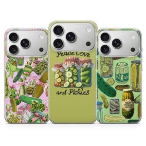 May include: Three smartphone cases featuring pickle-themed designs. The left case has a pink background with pickles and pink bows. The center case is light green with three jars of pickles and the text Peace Love and Pickles. The right case is green with various pickle jars and individual pickles.