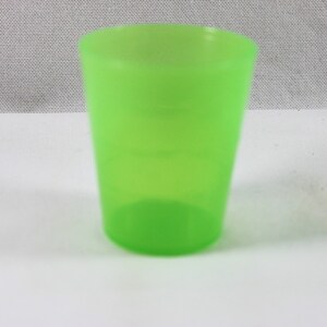 May include: A bright green plastic cup. The cup is empty and has a smooth surface.