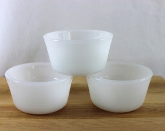 May include: Three white ceramic bowls stacked on top of each other. The bowls are round and have a smooth, glossy finish.