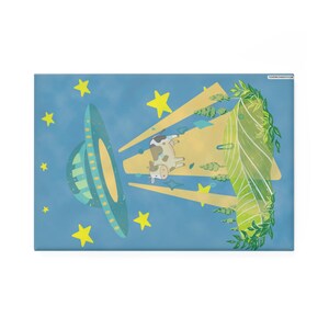 May include: A cartoon illustration shows a cow being abducted by a teal and yellow UFO against a blue starry sky. Yellow stars and green foliage frame the scene, creating a playful, cartoonish aesthetic. The artwork is a fun, imaginative piece.