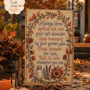 Peut inclure: Un drapeau de jardin rectangulaire avec un fond crème présentant un motif matelassé imprimé. Il affiche une couronne de feuilles d'automne, de baies et de fleurs entourant le texte : Always throw spilled salt over your left shoulder. Keep rosemary by your garden gate. Plant lavender for luck. Fall in love whenever you can. Une salière, des brins de lavande et un tournesol sont situés en bas.