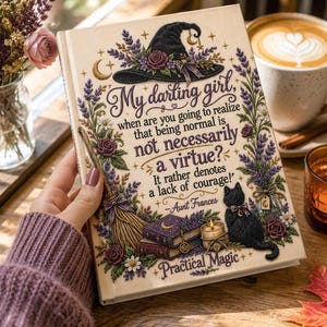 May include: A hardcover book with a cream-colored cover featuring a black witch hat, a broom, a black cat, stacked purple books, a candle, and lavender sprigs. The text reads: My darling girl, when are you going to realize that being normal is not necessarily a virtue? It rather denotes a lack of courage! -Aunt Frances, Practical Magic.