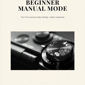 Op de afbeelding: Zwart-wit afbeelding van een camerabedieningsknop, met de tekst "BEGINNER MANUAL MODE" en "Your first manual mode settings, simply explained." De knop bevat instellingen zoals "M", "Av", "TV" en "AUTO". Het Tab & Tally Studio-logo staat onderaan.