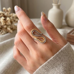 Chunky Two Tone Ring, Gold Silver Swirl Statement Ring for Women, Mixed Metal Open Wave Ring, Waterproof Adjustable, Gift for Her

#TwoToneRing #MixedMetalRing #GoldSilverRing #SwirlRing #StatementRing #ChunkyRing #WaterproofJewelry #OpenRing #WaveRing #AbstractJewelry #SculpturalJewelry #ModernJewelry #StatementJewelry #StainlessSteelJewelry #BoldJewelry #JewelryLover #SquiggleRing #AdjustableRing #GoldJewelry #GiftForHer #RingStack #EtsyJewelry #EtsyFinds #ShopSmall #JewelryGram