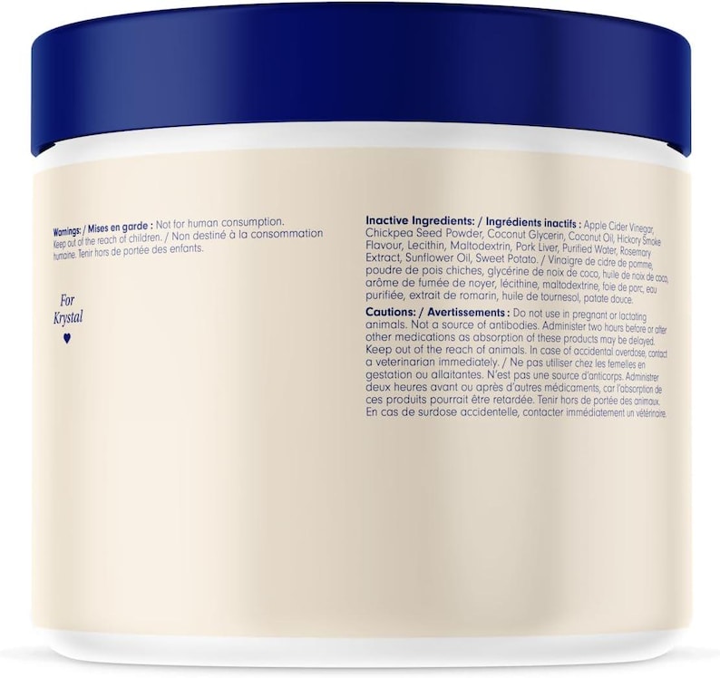 Op de afbeelding: Een witte cilindrische container met een donkerblauwe deksel. Het etiket bevat tekst over ingredi&euml;nten en waarschuwingen. De tekst "For Krystal" is ook zichtbaar. Het product is voor diergebruik.