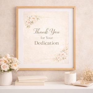 Puede incluir: Una impresión enmarcada con el texto "Thank You for Your Dedication" en escritura elegante. La impresión está decorada con detalles florales y enmarcada en un marco de madera clara. La imagen está sobre una superficie blanca con un jarrón de flores, libros y una vela.