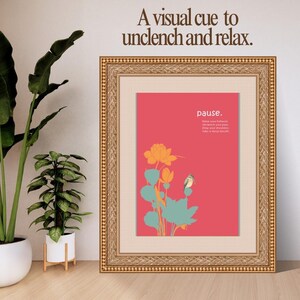 Könnte beinhalten: Gerahmter Kunstdruck mit goldfarbenem Rahmen. Der Druck zeigt einen korallenfarbenen Hintergrund mit einer floralen Illustration in Orange und Türkis. Der Text oben lautet: „Ein visueller Hinweis zum Entspannen“. Das Wort „Pause“ steht in Weiß.