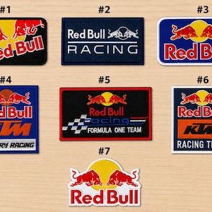 May include: A collection of seven rectangular and shaped embroidered patches featuring various Red Bull and racing team logos. The designs include the Red Bull bulls and sun emblem, Red Bull Racing, KTM Factory Racing, and Formula One Team branding.