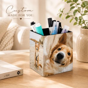 Peut inclure: Un organisateur de bureau carré avec une impression photo personnalisée d'un chien brun clair assis sur une plage de sable et un gros plan du visage du même chien. Le récipient contient plusieurs stylos et marqueurs, avec le texte Custom MADE FOR YOU.