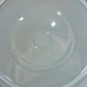 May include: A clear, circular Tupperware lid with the brand name embossed around the edge. The lid has a central circular indentation and the number "6" is visible. The number "344-1" is printed on the lid.
