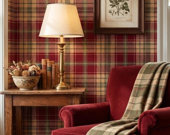 May include: A red velvet armchair draped with a green and tan plaid throw blanket, positioned next to a wooden side table holding a brass lamp, a bowl of dried botanicals, and several books, all set against a red and tan plaid wallpaper.