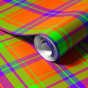 Puede incluir: Un rollo de papel de regalo con un vibrante patrón de cuadros. El diseño consiste en cuadrados de color naranja brillante cruzados por audaces rayas diagonales en verde neón y morado intenso que crean una cuadrícula geométrica de alto contraste.