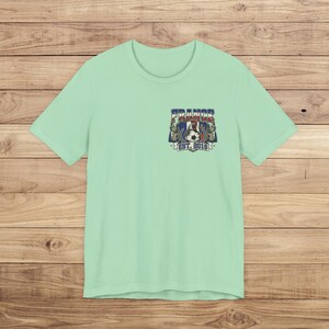 May include: A light mint green short-sleeve t-shirt featuring a small graphic on the left chest. The design includes a rooster, a soccer ball, and the text "FRANCE" above and "EST. 2018" below, all rendered in red, white, and blue colors.