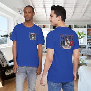 May include: A royal blue short-sleeve t-shirt featuring a small graphic on the front chest and a large graphic on the back. The back design displays the text FRANCE 2018, a soccer trophy, the Eiffel Tower, and the text Fiers d'&ecirc;tre champions.