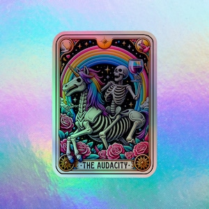 May include: A holographic sticker featuring a skeleton riding a skeletal unicorn through a rainbow. The skeleton holds a wine glass. The sticker is framed with roses and the text "THE AUDACITY."