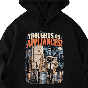 May include: A black hooded sweatshirt featuring a graphic print with the text "THOUGHTS ON APPLIANCES?" and "THE CASE HAS GONE COLD." The illustration depicts a refrigerator and a microwave wearing trench coats and ties walking in a city at night.