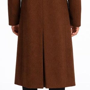 May include: A long, brown wool coat with a classic design. The coat features a tailored fit, long sleeves, and a split back. The coat is made of a textured fabric and is suitable for cold weather. The coat is a versatile piece of outerwear.