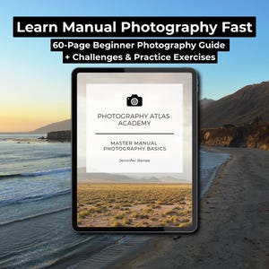 May include: A tablet displays a photography guide with the text "Learn Manual Photography Fast." The guide, from Photography Atlas Academy, promises a 60-page beginner's guide with challenges and exercises. The background shows a coastal landscape with a sunset.
