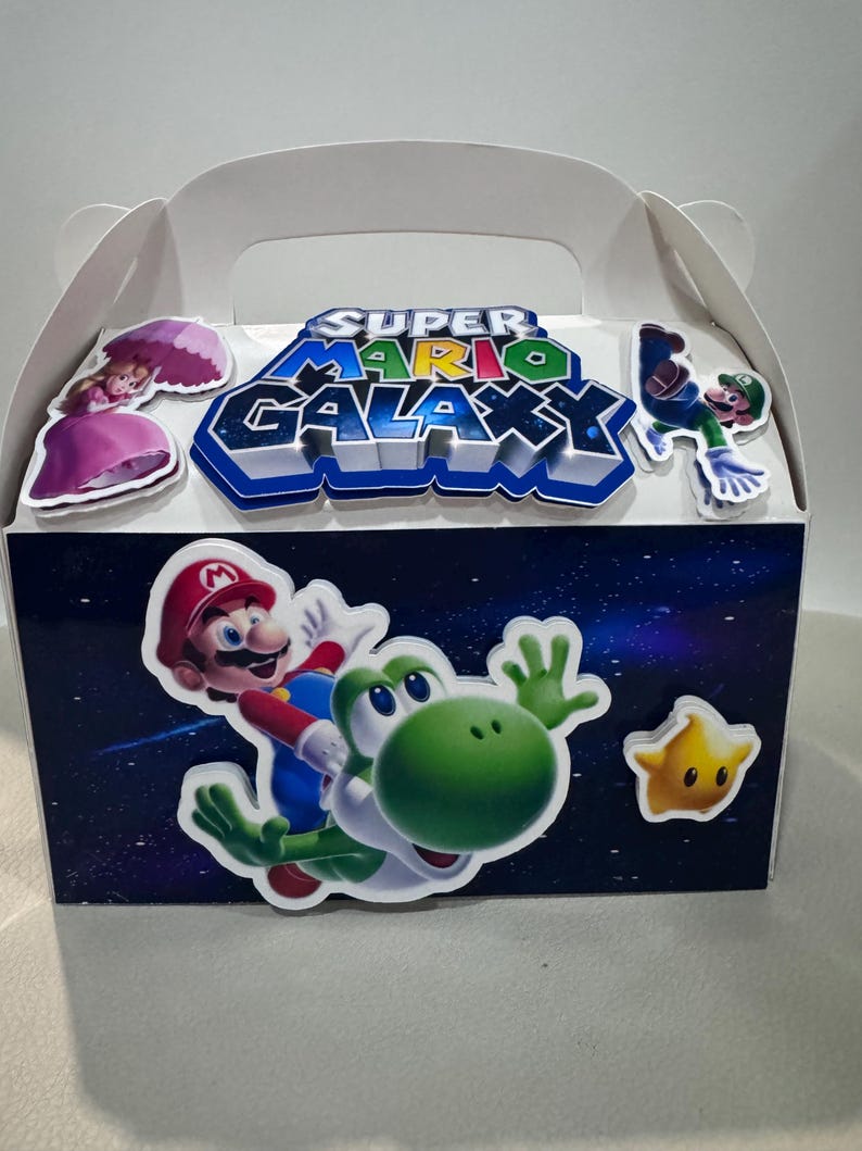 white party box with a handle, featuring a galaxy theme with super Mario, princess peach and Rosalina, yoshi, luma, Luigi and bowser jr as wonder. The box is decorated with  3D characters. The box is designed for party favors. includes Mario stickers