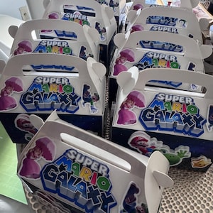 K&ouml;nnte beinhalten: Eine wei&szlig;e Keramik-Tasse mit schwarzem Henkel und dem Text "But First, Coffee" in schwarzer, fetter Schrift. Die Tasse steht auf einer Holzoberfl&auml;che.