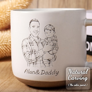 May include: White ceramic mug with a brown base, featuring an engraved illustration of a father and child. The mug is inscribed with "Alan & Daddy" and "Natural Carving" text. The mug has a handle and is suitable for hot beverages.