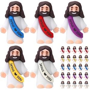 May include: A collection of small Jesus figurines with brown hair and beards, wearing white robes and colorful sashes. The sashes are in various colors, including blue, red, yellow, and purple, with the words "Jesus" and "You" printed on them.