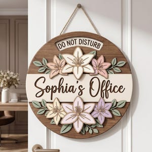 May include: A circular wooden door sign featuring the text "DO NOT DISTURB" at the top and "Sophia's Office" in the center. The sign is decorated with layered, pastel-colored floral cutouts in shades of pink, yellow, and purple, accented by green leaves.