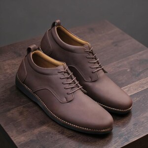 May include: A pair of brown leather dress shoes with a lace-up design. The shoes have a rounded toe and a pull tab at the heel. The soles are dark brown with white stitching.