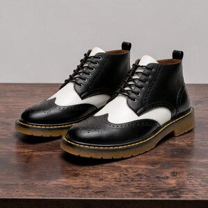 May include: A pair of two-tone black and white leather ankle boots with a classic brogue design. The boots feature a lace-up closure, a rounded toe, and a thick, light brown sole with a yellow accent. The boots are displayed on a wooden surface.