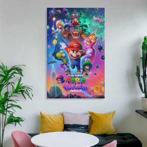 May include: A framed movie poster for "The Super Mario Bros. Movie" featuring Mario, Luigi, Princess Peach, Bowser, and other characters against a colorful space-themed background. The poster is displayed on a white wall above a sofa with yellow and pink pillows.