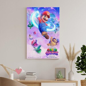 May include: A framed movie poster for "The Super Mario Bros. Movie." The poster features Mario in a dynamic pose, surrounded by animated characters and a vibrant, colorful background. The movie title is prominently displayed.