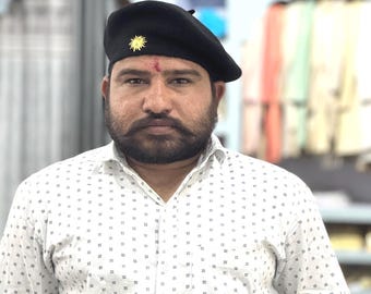 Berretto da uomo nero con spilla dorata