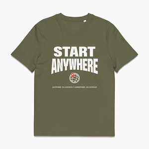 Könnte beinhalten: Ein olivgrünes Kurzarm-T-Shirt mit dem weißen Schriftzug START ANYWHERE über einem weißen Linien-Globus-Symbol mit einer roten Kartenmarkierung. Darunter steht der Text LATITUDE: XX.XXXXXX | LONGITUDE: XX.XXXXXX in weißen Großbuchstaben.