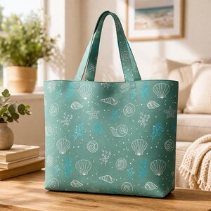 May include: A teal tote bag with white and blue seashell and coral patterns. The bag has a rectangular shape with a matching teal handle. The design includes various seashells, starfish, and coral illustrations.