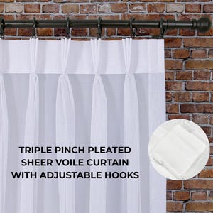 May include: White sheer voile curtain with triple pinch pleats and adjustable hooks, hanging from a dark brown rod. The text on the image reads: "TRIPLE PINCH PLEATED SHEER VOILE CURTAIN WITH ADJUSTABLE HOOKS."