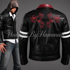 May include: Black leather jacket with red dragon embroidery on the back. Features white stripes on the sleeves and a red collar. The jacket has a zipper closure and the text "Vintage By Hammad".