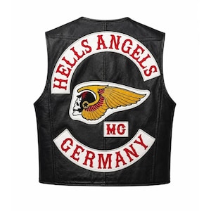 Könnte beinhalten: Eine schwarze Lederweste mit einem großen gestickten Aufnäher auf der Rückseite. Der Aufnäher zeigt den Schriftzug HELLS ANGELS in Rot auf einem weißen Bogen, ein zentrales geflügeltes Totenkopf-Emblem in Gelb und Rot sowie GERMANY in Rot.