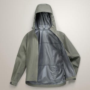 Puede incluir: Chaqueta con capucha verde salvia con cremallera completa. La chaqueta est&aacute; abierta, revelando un forro interior plateado. La capucha est&aacute; levantada y las mangas extendidas. Esta chaqueta impermeable est&aacute; dise&ntilde;ada para actividades al aire libre.