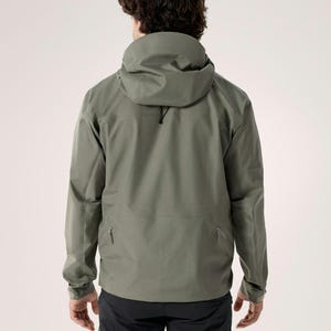 Puede incluir: Chaqueta con capucha verde salvia con cuello alto y cord&oacute;n. La chaqueta tiene dos bolsillos con cremallera y mangas largas. El modelo lleva pantalones negros. La chaqueta est&aacute; dise&ntilde;ada para actividades al aire libre.