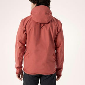 Puede incluir: Chaqueta con capucha de color &oacute;xido con cuello alto y bolsillo delantero. La chaqueta tiene mangas largas y una capucha con cord&oacute;n. La persona de la imagen lleva pantalones negros. La chaqueta est&aacute; hecha de un material duradero y resistente a la intemperie.