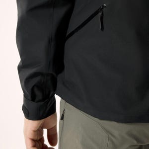 Puede incluir: Chaqueta negra con bolsillo con cremallera y pu&ntilde;o con cierre de velcro. La chaqueta se combina con pantalones grises con bolsillo con cremallera. La imagen muestra un primer plano de la chaqueta y los pantalones.