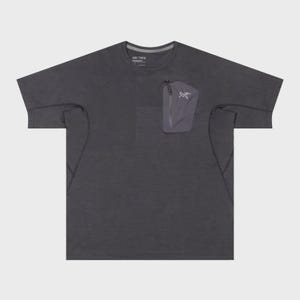 May include: Dark grey short-sleeve t-shirt with a small pocket on the chest. The pocket has a zipper and a white logo. The shirt has a crew neck and a subtle texture.