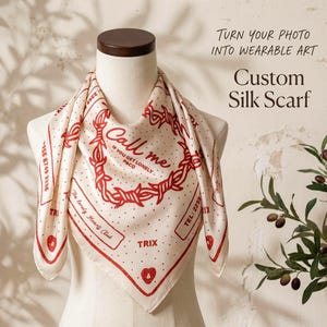 May include: A cream-colored silk scarf featuring a red graphic print of a barbed wire heart, the text "Call me IF YOU GET LONELY P&CO", "The Lonely Heart Club", "TRIX", and "TEL: 2256 8749 3336". The scarf is displayed on a mannequin bust.
