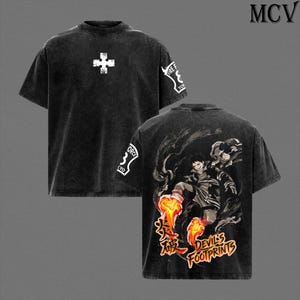 May include: Black graphic t-shirt with a white cross on the front and Japanese text and a character illustration on the back. The sleeves have white text and a logo. The shirt is a dark, faded color.