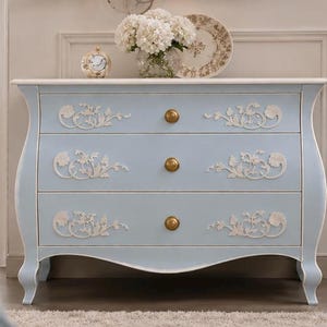 Cómoda de lujo azul cielo con incrustaciones florales en hueso y tapa de mármol blanco.