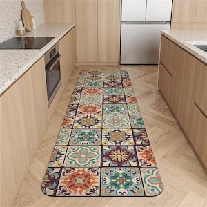 May include: A long rectangular kitchen runner rug featuring a repeating grid pattern of colorful tiles. The design includes various floral and geometric motifs in shades of teal, orange, yellow, purple, and cream, creating a vibrant mosaic effect.
