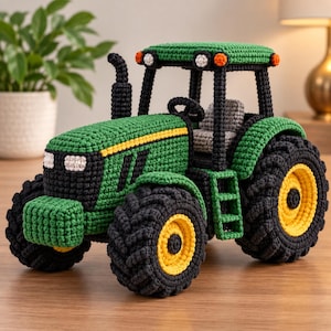 May include: A handcrafted crochet tractor featuring a green body with black accents, a yellow stripe, and large black tires with yellow centers. The vehicle includes a grey seat, a black exhaust pipe, and small orange and white lights on the roof.
